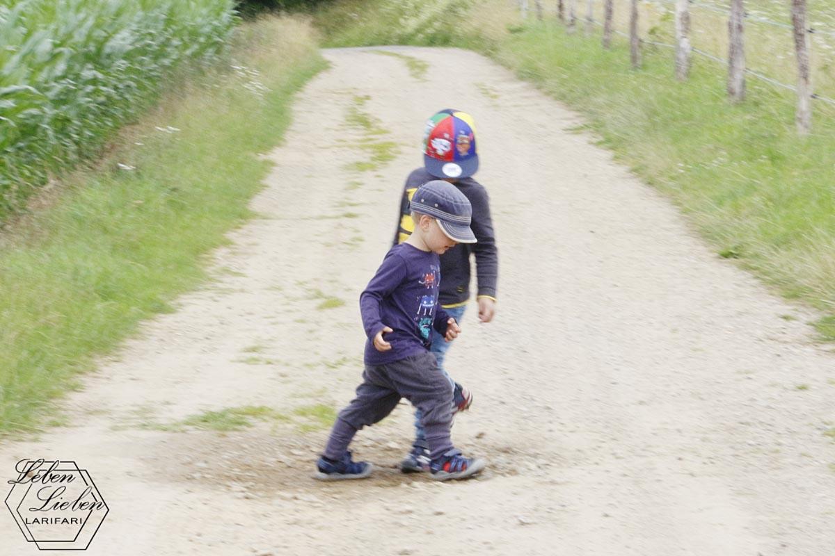 2 Kinder stehen in einer Matschpfütze