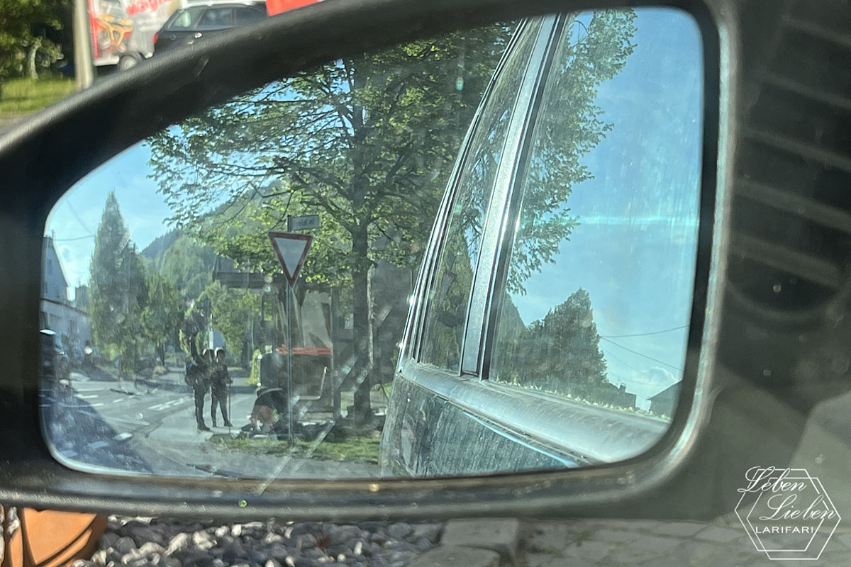In einem Seitenspiegel sind Kinder an der Bushaltestelle zu sehen