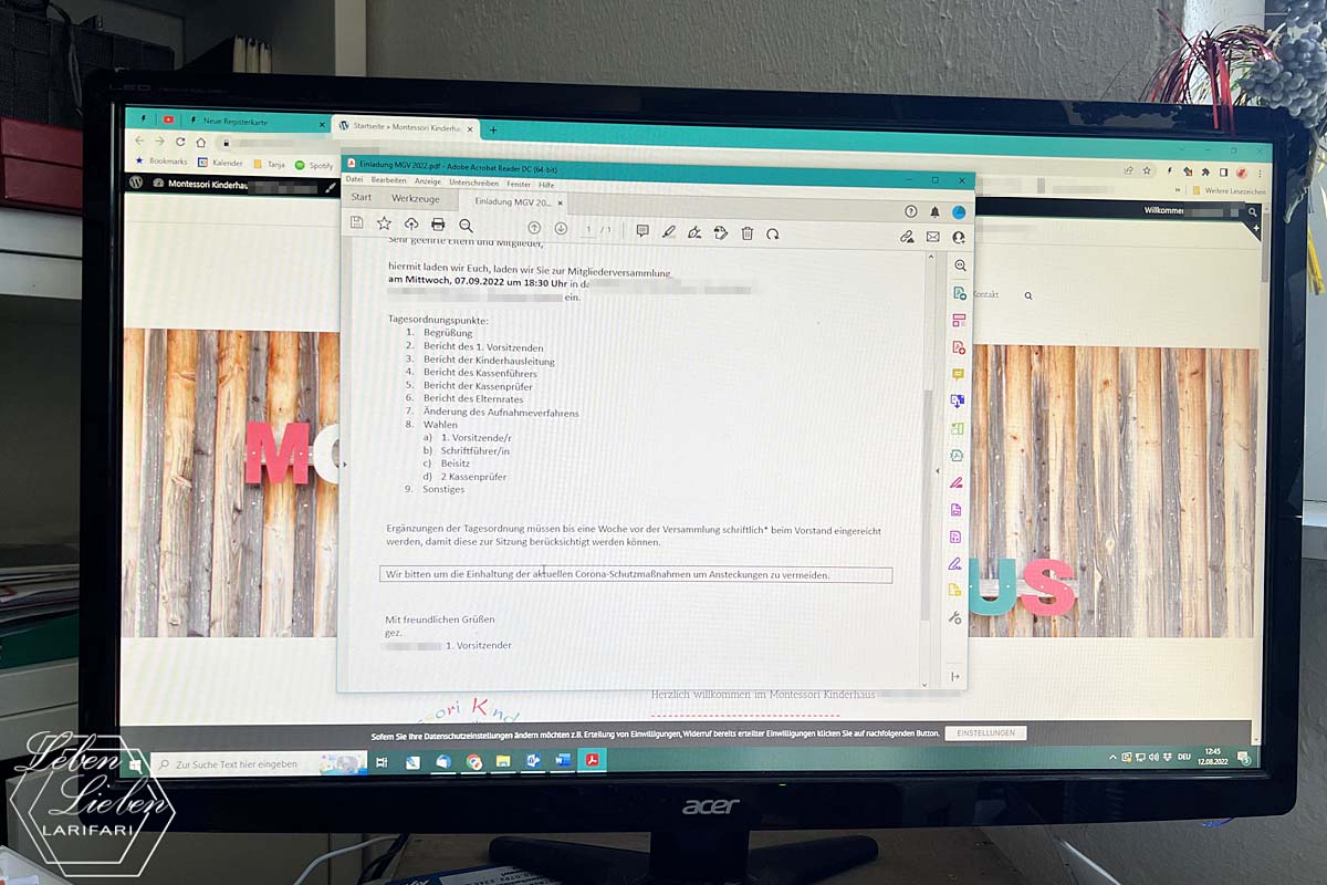 Ein PC-Bildschirm zeigt eine MGV-Einladung und im Kindergrund die Webseite des Kinderhauses