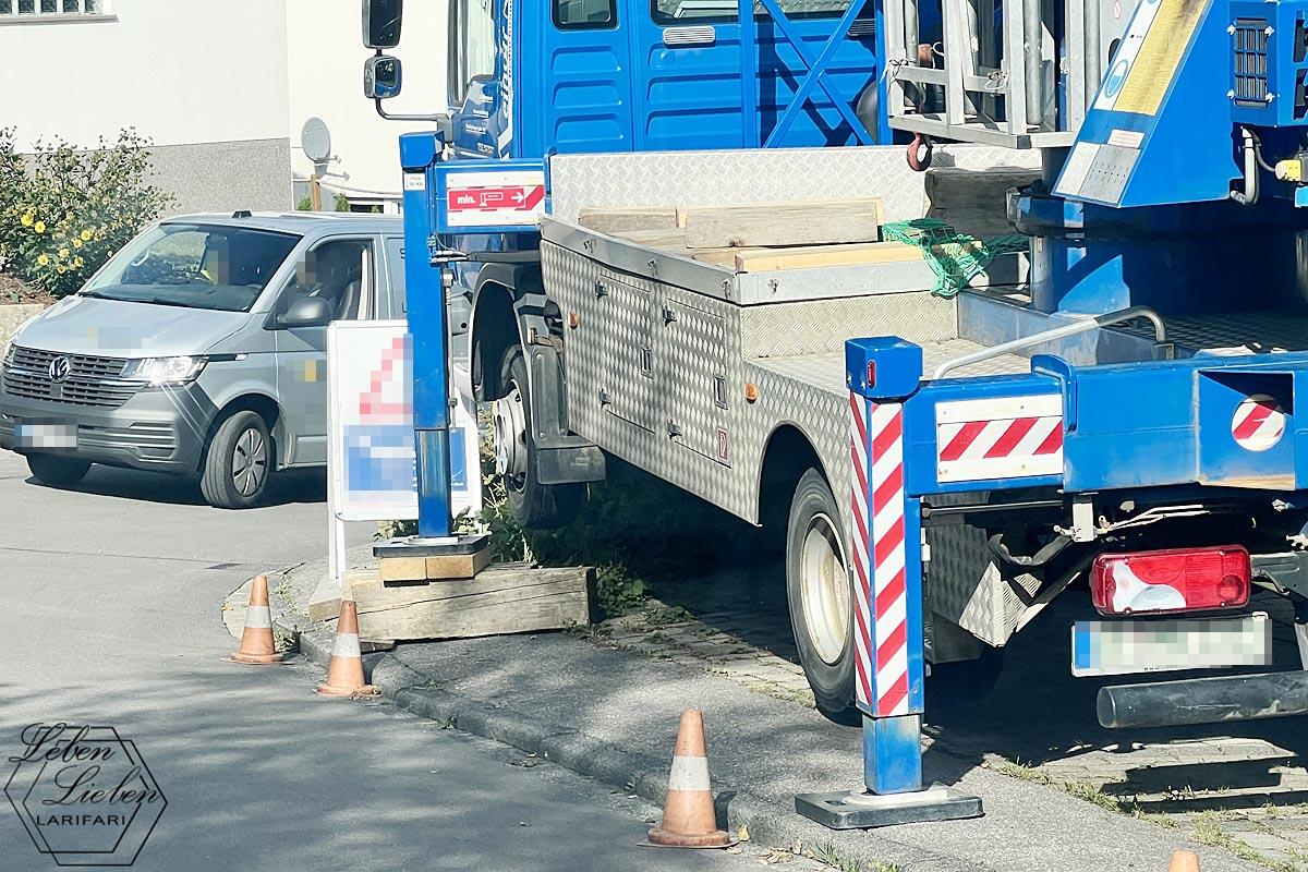 Der Kranwagen des Dachdeckers hat die Stütrzen erhöht