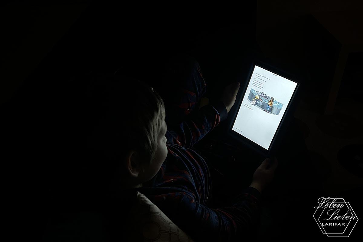 Eine Kinder-Silhouette ist im Schein des Tablets zu erkennen