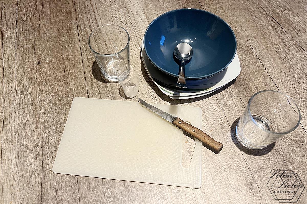 Teller, Schale, Brettchen, Löffel, Messer, Gläser und Medikamentenpinnchen stehen auf dem Tisch