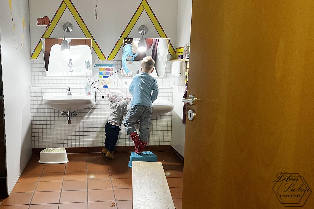 2 Kinder stehen an einem Waschbecken im Waschraum des Kindergartens.
