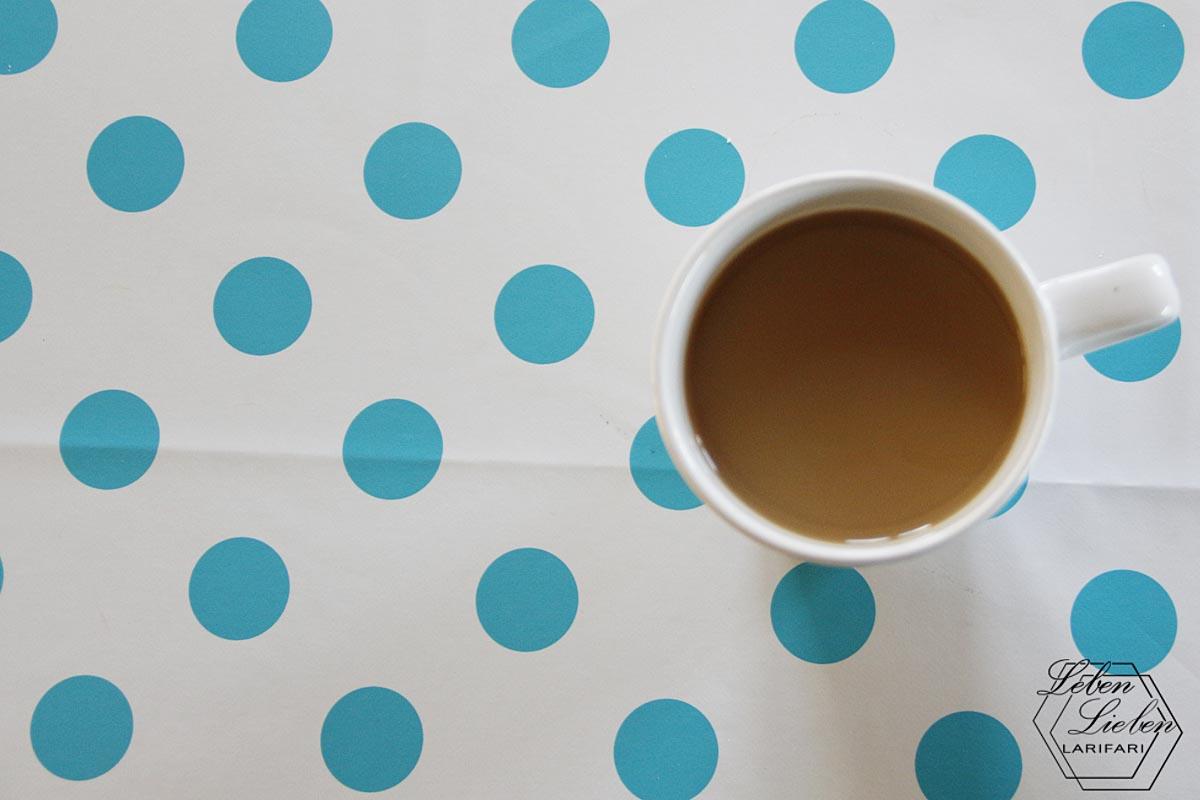 Tasse Kaffee auf dem gepunkteten Tisch